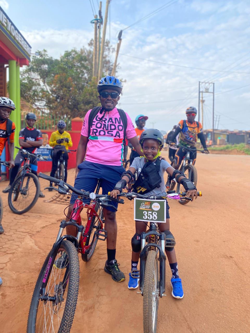 A father and son duo with race bib 358 at a community cycling event