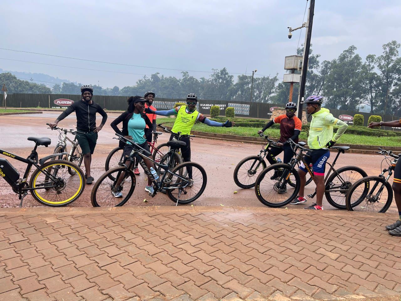 Group of eight cyclists gathered together on a paved courtyard