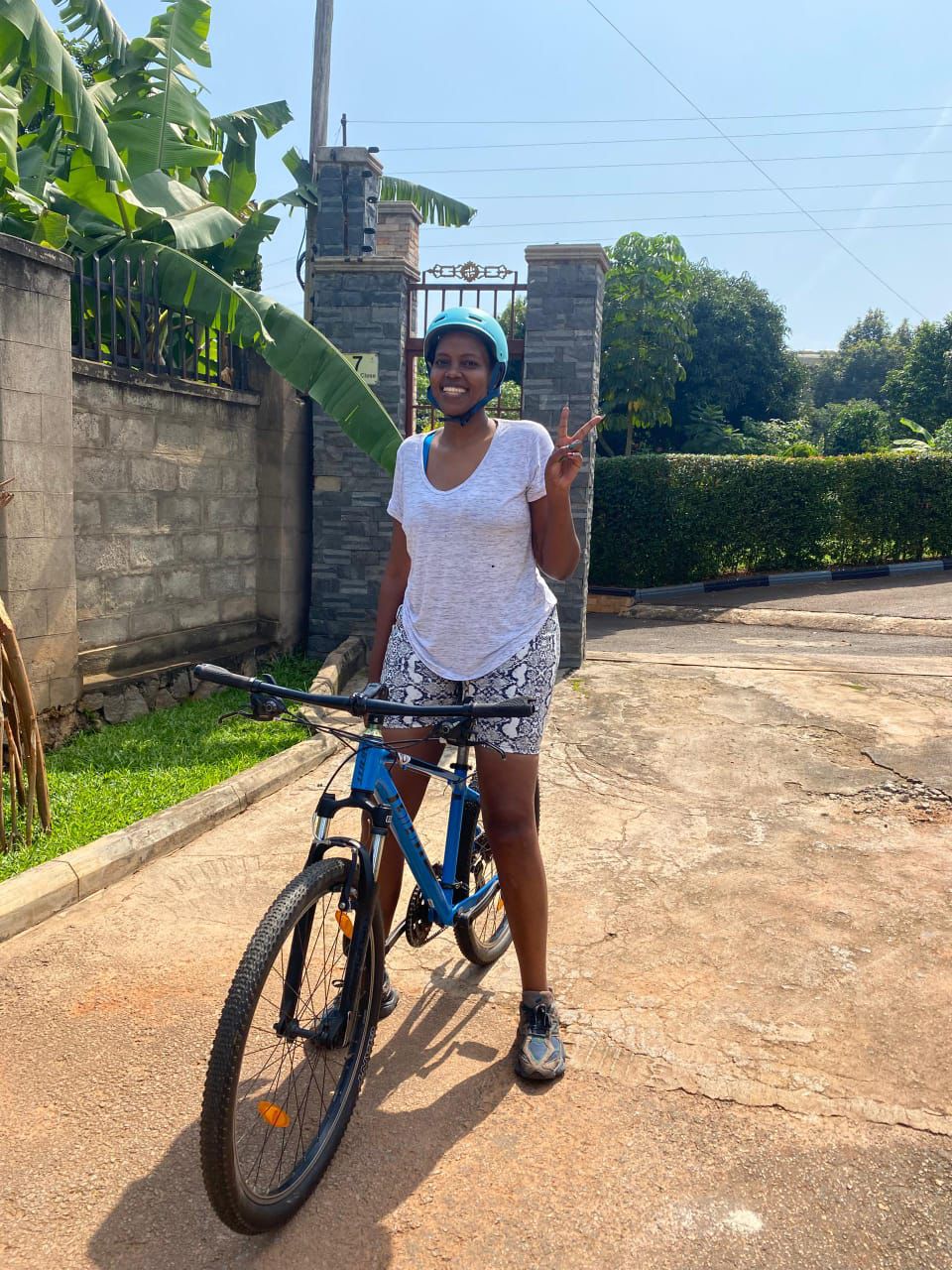 Rider giving a peace sign in front of a gated compound