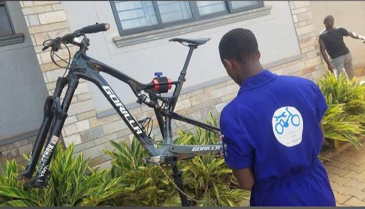 Mechanic inspecting a full-suspension mountain bike outside a house